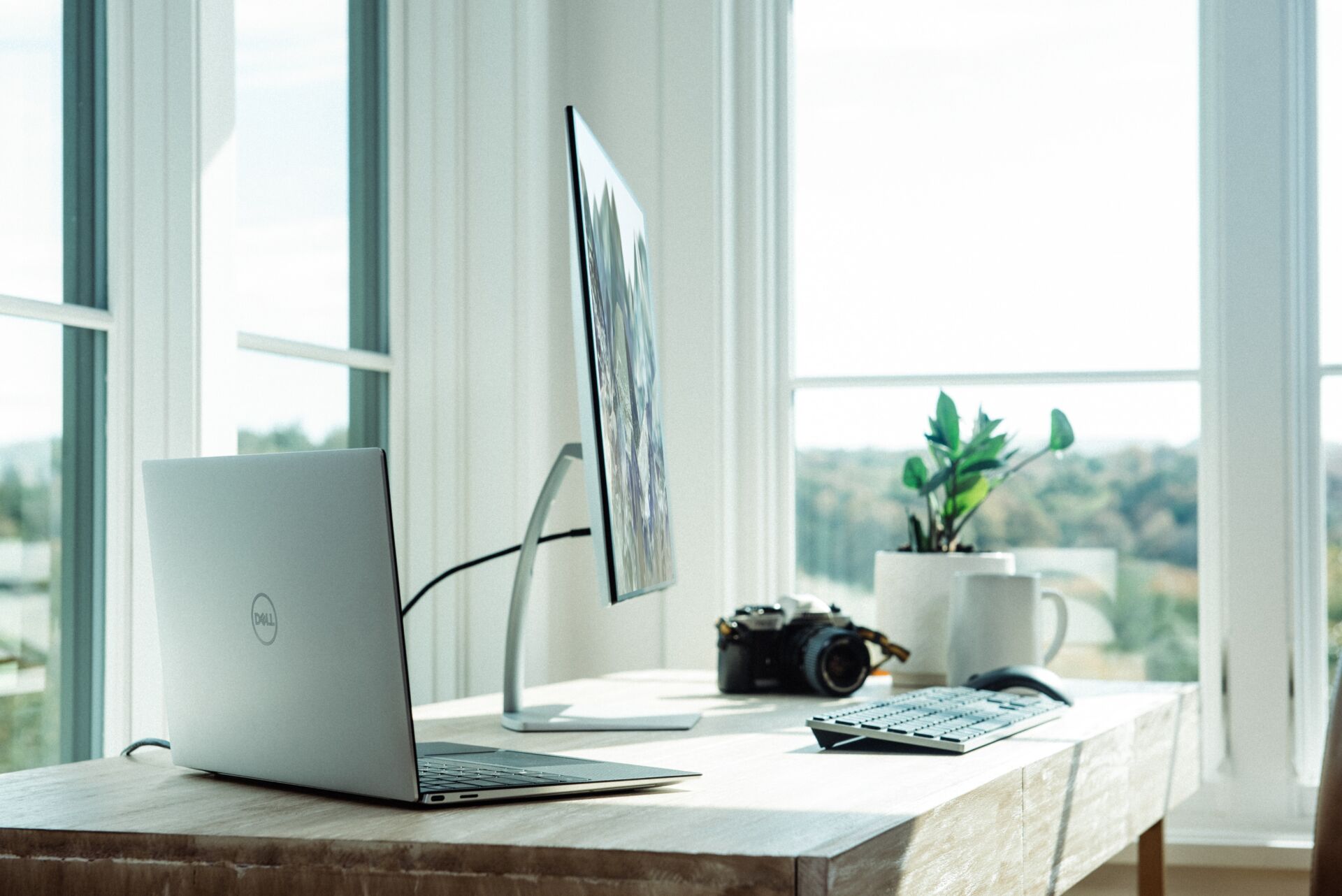 A desk with a laptop, monitor and camera