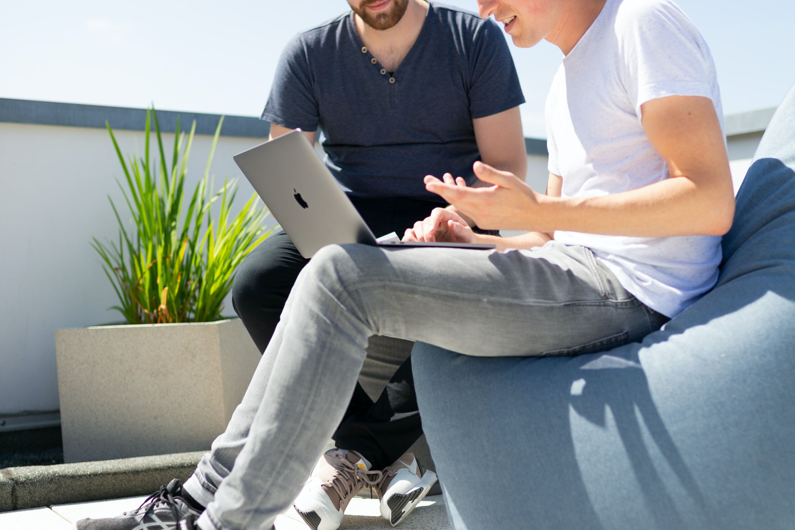 Two men sitting outside using JetStream on a laptop